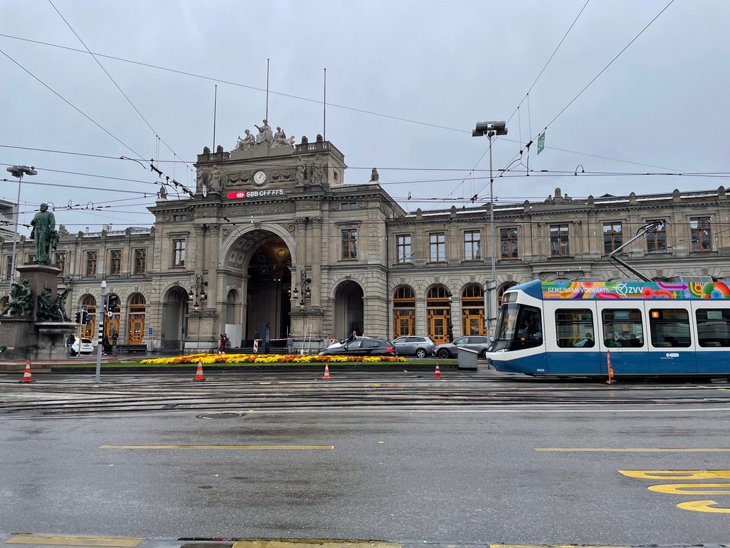 La stazione ferroviaria di Zurigo con un tram che passa davanti.